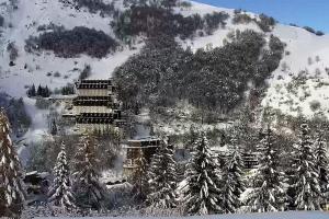 a snow covered mountain with trees and a building at Casa Amy in Sella della Turra