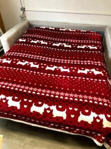 a bed with a red blanket with horses on it at Casa Amy in Sella della Turra
