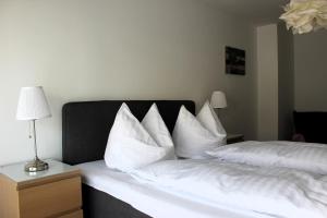 een slaapkamer met een bed met witte lakens en kussens bij Mountain View City Center in Innsbruck