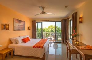 a bedroom with a bed and a desk and a window at Srisuksant Resort in Ao Nang Beach