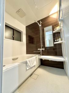 a bathroom with a sink and a bath tub at 最大10名で泊まれる貸別荘日本橋駅徒歩5分黒門市場に隣接し道頓堀 难波 心斎橋徒歩圏内 in Osaka