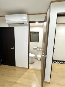 an open door to a bathroom with a toilet at 最大10名で泊まれる貸別荘日本橋駅徒歩5分黒門市場に隣接し道頓堀 难波 心斎橋徒歩圏内 in Osaka +39 photos