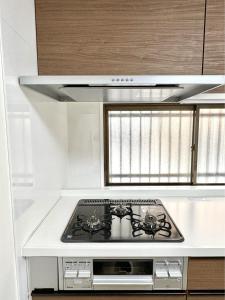 a stove top oven in a kitchen with a window at 最大10名で泊まれる貸別荘日本橋駅徒歩5分黒門市場に隣接し道頓堀 难波 心斎橋徒歩圏内 in Osaka