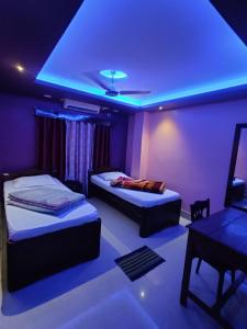 a room with two beds and a blue light at DAS HOTEL in Darjeeling