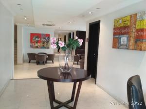 a vase of flowers on a table in a room at S & S Hotel & Suites in Lagos