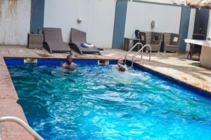 a man and a child in a swimming pool at S & S Hotel & Suites in Lagos