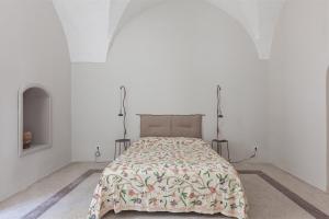 a bed in a white room with a blanket on it at Palazzo Favola Dimora in town centre - Happy Rentals in Corigliano dʼOtranto