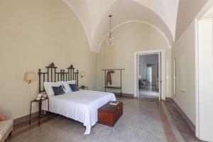 a bedroom with a large white bed and an archway at Palazzo Favola Dimora in town centre - Happy Rentals in Corigliano dʼOtranto +31 photos