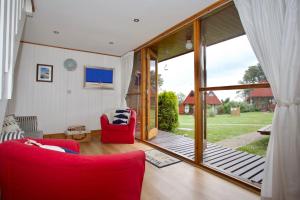 een woonkamer met een rode bank en een glazen schuifdeur bij Chalet Fortythree in Deal