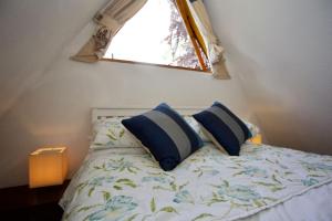 een bed met blauwe kussens in een slaapkamer met een raam bij Chalet Fortythree in Deal