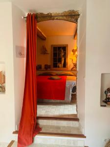 a bedroom with a red bed in a room at Le monde de Théodore in Anduze