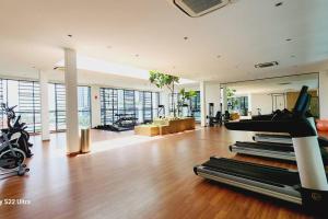 a gym with treadmills and exercise equipment in a room at Santorini Holiday Resort Style Staycation 3 rooms in Shah Alam