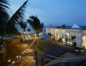 a resort with chairs and umbrellas on the beach at night at Sea Mê Homestay - by Bay Luxury in Cu Lao Thu