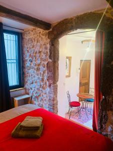 a bedroom with a red bed and a table and chairs at Le monde de Théodore in Anduze