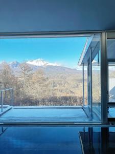 a room with a view of a mountain through a window at 軽井沢天空ホテル＆リゾート in Karuizawa