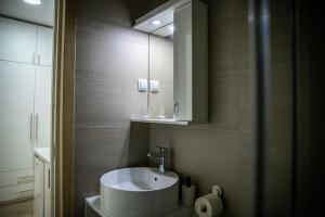La salle de bains est pourvue d'un lavabo blanc et d'un miroir. dans l'établissement Jelena Apartmani, à Sombor
