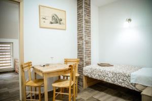 - une chambre avec un lit, une table en bois et des chaises dans l'établissement Jelena Apartmani, à Sombor
