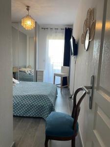 a bedroom with a bed and a chair and a window at Magnifique 2 pièces Juan Les Pins in Antibes
