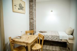 Cette chambre comprend une table, un lit, une table et des chaises. dans l'établissement Jelena Apartmani, à Sombor