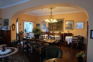 Hotel Villa Nettuno في تاورمينا: غرفة طعام بها طاولات وكراسي وثريا