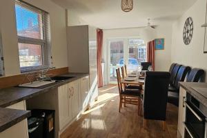 a kitchen and dining room with a table and chairs at Avocet View *sleeps 10* in Exmouth