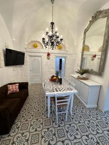 een woonkamer met een tafel en een kroonluchter bij Trullo Imperiale in Cisternino