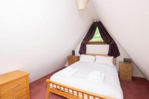 1 dormitorio con cama blanca y ventana en Chalet Sixtytwo, en Deal