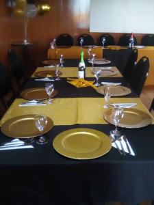 a long table with plates and wine glasses on it at Monokotsoaing Guest House in Leribe