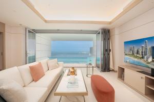 a living room with a white couch and a view of the ocean at FIVE LUXE in Dubai