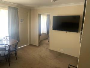 a room with a table and a television on the wall at Albion Hotel in Kalgoorlie