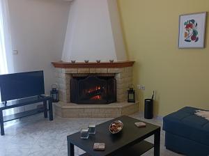 a living room with a fireplace and a couch at Kelly's penthouse in Nafpaktos