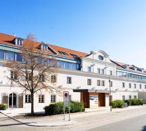 a large white building with a red roof on a street at Hotel Auszeit St Lambrecht in Sankt Lambrecht