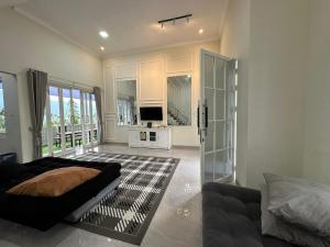 Una sala de estar con un sofá y un televisor. en Daisha Villa - Batu (Private Pool), en Punten