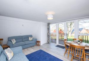 een woonkamer met een blauwe bank en een tafel bij Chalet Sixtysix in Deal