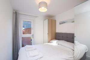 een slaapkamer met een bed met witte lakens en een raam bij Chalet Sixtysix in Deal