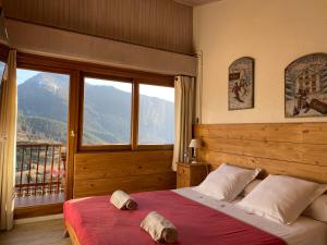 a bedroom with a bed and a large window at Chambres d'hôtes Le Grand Chalet in Valdeblore