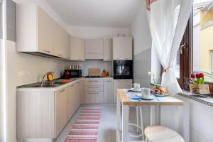 a kitchen with white cabinets and a wooden table at Casa Miriam in Oristano