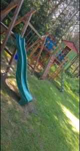 a playground with a slide in the grass at Agro Rancho domki in Podgórzyn