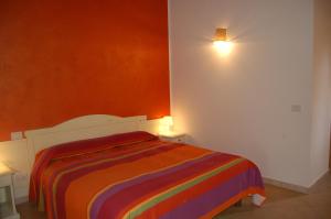 - une chambre avec un lit arc-en-ciel dans l'établissement Agriturismo Villa Degli Ulivi, à San Vero Milis