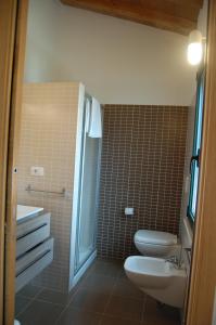 La salle de bains est pourvue de toilettes, d'un lavabo et d'une douche. dans l'établissement Agriturismo Villa Degli Ulivi, à San Vero Milis
