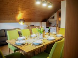 una mesa de madera con sillas verdes y un comedor en ERLEBNISBAUERNHOF Steinerhof in Kärnten, en Liebenfels