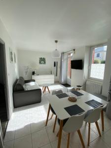 a living room with a table and a couch at Le Clousy- Gîte - CARQUEFOU Centre in Carquefou