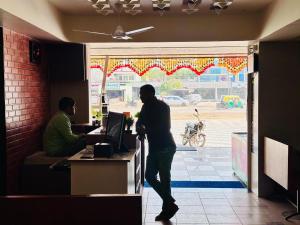 two men standing at a counter in a restaurant at HOTEL SAHYOG in Rādhanpur +20 photos