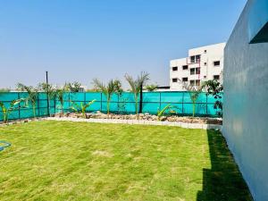 a green yard with a fence and a building at HOTEL SAHYOG in Rādhanpur