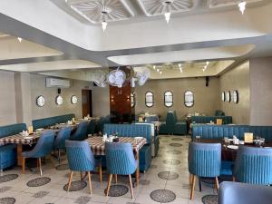 a dining room with blue chairs and tables at HOTEL SAHYOG in Rādhanpur