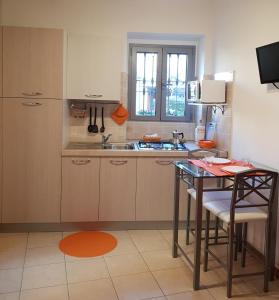 eine Küche mit einem Tisch und einem Waschbecken in der Unterkunft La Casetta in centro storico a Stresa in Stresa