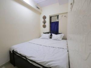 Cette petite chambre blanche comprend un lit. dans l'établissement Solace - 1 BHK - Walk away from Carter road, à Mumbai