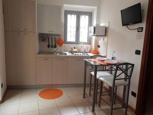 eine kleine Küche mit einem Tisch und einem Waschbecken in der Unterkunft La Casetta in centro storico a Stresa in Stresa