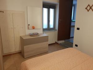 Schlafzimmer mit einem Bett, einer Kommode und einem Spiegel in der Unterkunft La Casetta in centro storico a Stresa in Stresa