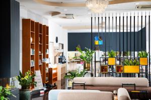 a lobby with couches and potted plants at Bo33 Hotel Family & Suites in Budapest